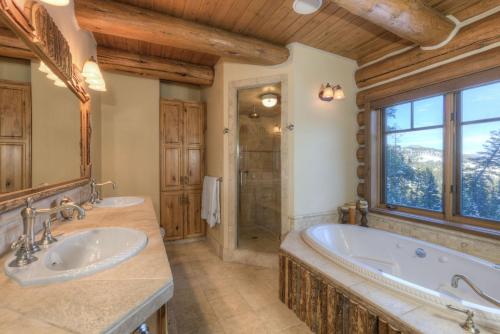 baño con 2 lavabos, bañera y ventana en MV Leaf Lodge, en Big Sky