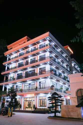 a large white building with lights on it at night at Phú Long Tam Kỳ Hotel & Restaurant in Tam Ky