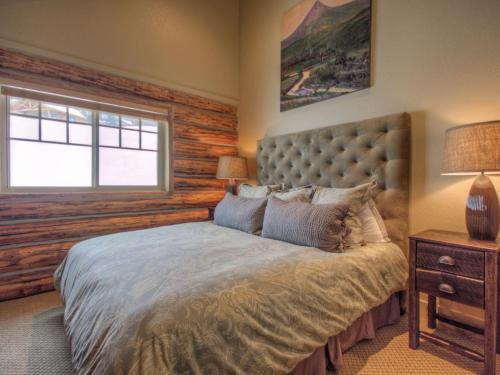 een slaapkamer met een groot bed en een raam bij Cowboy Heaven Cabin 15 Derringer in Big Sky