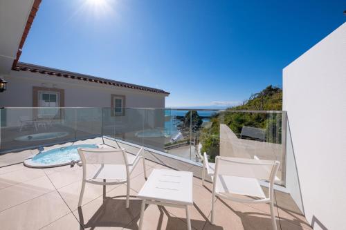 a balcony with white chairs and a swimming pool at Hayama Hotel Otowa No Mori in Yokosuka