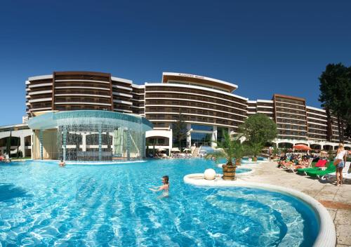 una persona en una piscina frente a un hotel en Flamingo Grand Hotel & Spa, en Albena