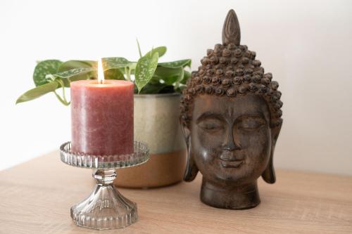 a candle and a statue on a table with a plant at Pretty Jolie Romantic Getaway in Bled