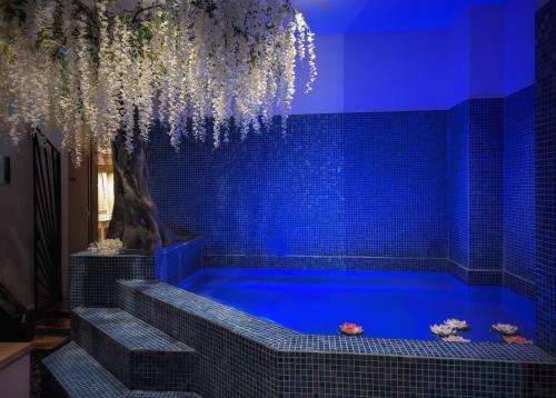 una vasca blu in una stanza con piastrelle blu di Leprince Hotel Spa; Best Western Premier Collection a Le Mans