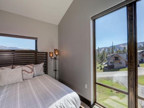 a bedroom with a bed and a large window at Homestead Chalet 6 Claim Jumper in Big Sky