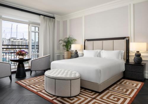 a bedroom with a large white bed and a balcony at Cape Grace, A Fairmont Managed Hotel in Cape Town