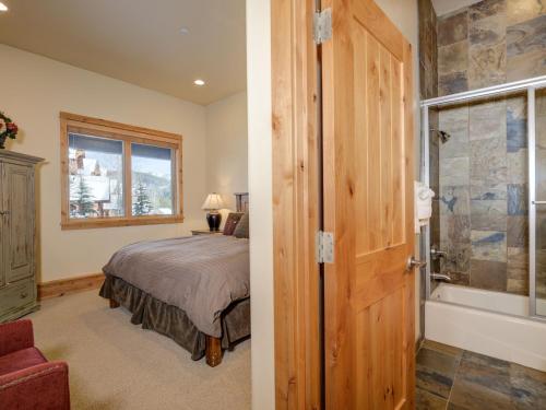 a bedroom with a bed and a bathroom with a shower at Black Eagle 31 in Big Sky