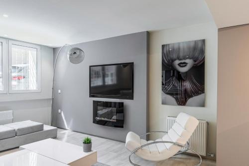uma sala de estar com um sofá branco e uma televisão em Mayer Hellas 2Br Duplex Kolonaki Apartment em Atenas