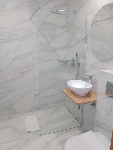 a white bathroom with a sink and a shower at Hotel Złoty Młyn Polichno in Polichno