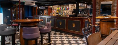 a bar with tables and chairs in a restaurant at Keppels Head Hotel in Portsmouth