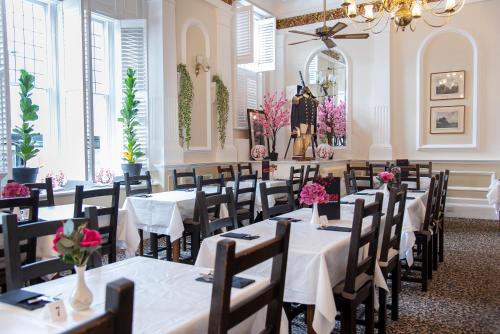 a dining room with tables and chairs with flowers on them at Keppels Head Hotel in Portsmouth