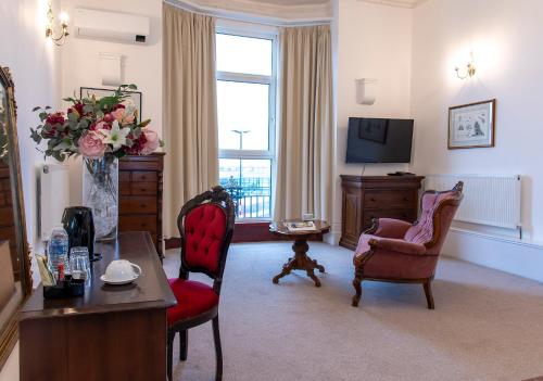 a living room with two chairs and a television at Keppels Head Hotel in Portsmouth