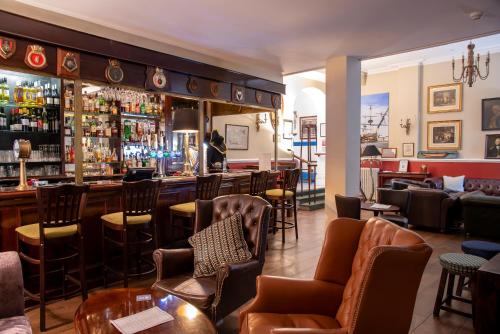 a bar at a restaurant with chairs and a counter at Keppels Head Hotel in Portsmouth