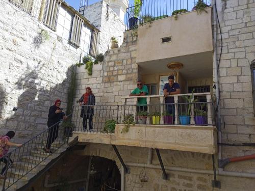 un groupe de personnes debout sur le balcon d'un bâtiment dans l'établissement BREAD HOUSE, à Bethléem