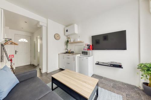 un salon avec un canapé et une table dans l'établissement Studio Cosy - proche Paris & Stade de France, à Pantin