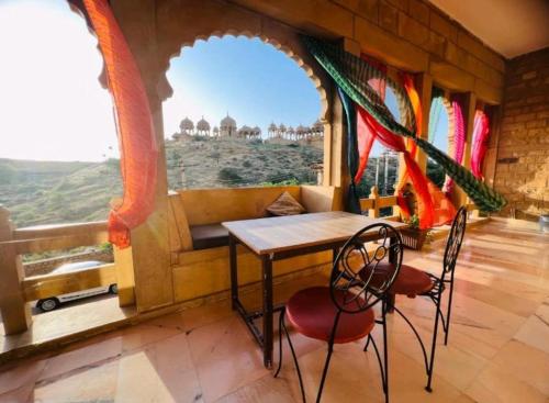 stół i krzesła w pokoju z widokiem w obiekcie Desert Moon Hotel w mieście Jaisalmer
