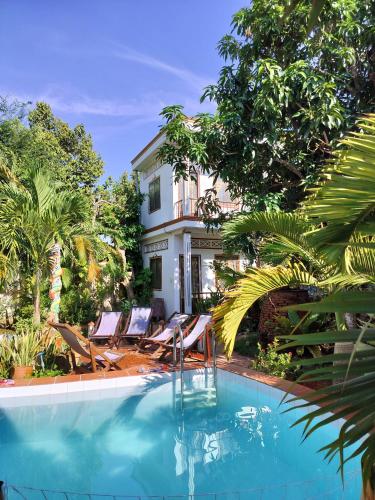 a house with chairs and a swimming pool at Happy Family Guesthouse in Vĩnh Long