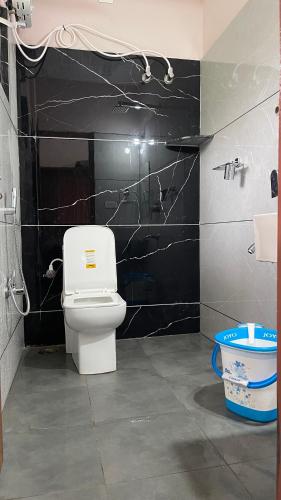a bathroom with a toilet and a black wall at Silver springs Homestay Chickmagalur in Chikmagalūr