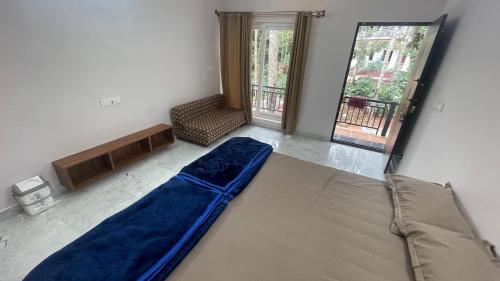 a room with a bed and a chair and a window at Silver springs Homestay Chickmagalur in Chikmagalūr