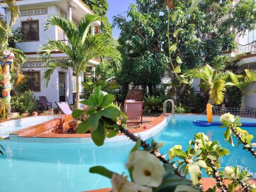 a pool in front of a house with trees at Happy Family Guesthouse in Vĩnh Long