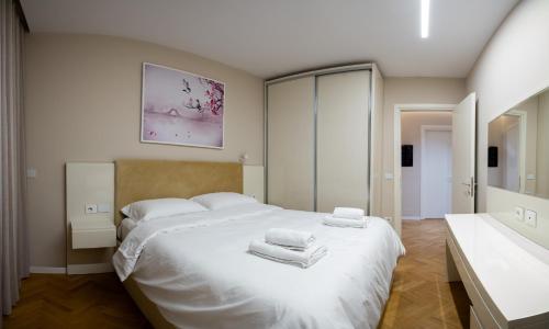 a bedroom with a white bed with towels on it at Center Tirana Liv apartment in Tirana