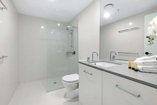 La salle de bains blanche est pourvue d'une douche et de toilettes. dans l'établissement Luxurious 2 Bedroom, 2 Bathroom, Ocean View Apartment - Wow Stay, à Gold Coast