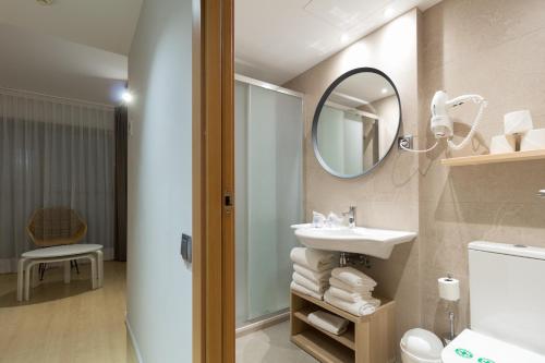 a bathroom with a sink and a mirror at Apartamentos Royal Marina Gardens in Castelldefels