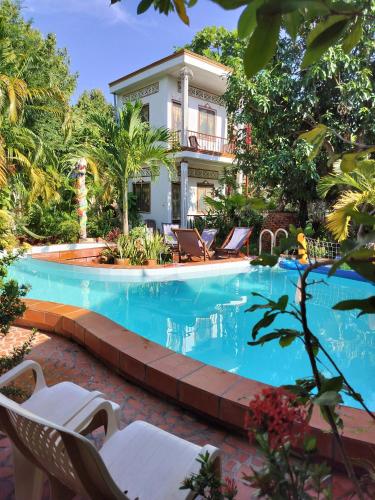 a swimming pool in front of a house at Happy Family Guesthouse in Vĩnh Long