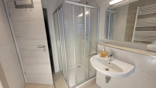 a white bathroom with a shower and a sink at Ferienwohnung Gartentraum mit tollem Rasengarten in Ostseebad Karlshagen