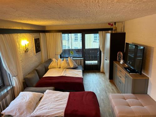 a hotel room with two beds and a flat screen tv at Andys Bergglück in Weidach