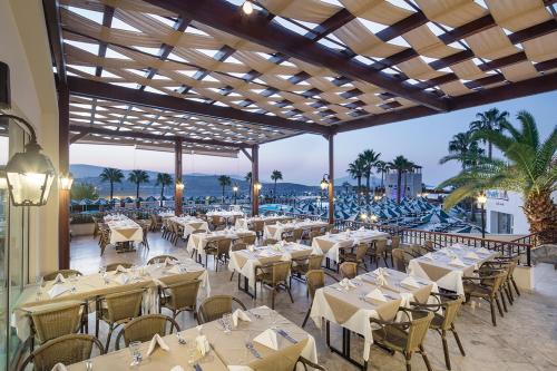グムベットにあるSelectum Colours Bodrumの白いテーブルと椅子が備わる海の景色を望むレストラン