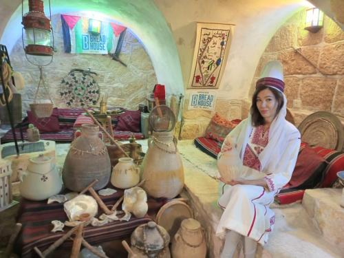 a woman is sitting in a room with pottery at BREAD HOUSE in Bethlehem