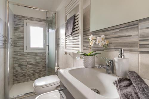 a white bathroom with a sink and a toilet at 45 minutes to Venice - By Flora in Fagarè della Battaglia