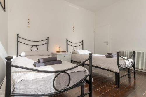 2 Betten in einem Zimmer mit weißen Wänden in der Unterkunft 45 minutes to Venice - By Flora in Fagarè della Battaglia