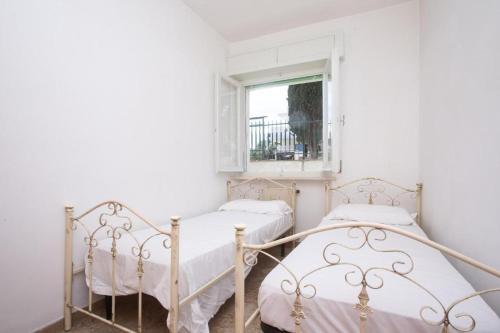 Duas camas num quarto branco com uma janela em Trilocale vicino al mare a Numana - N129 em Marcelli
