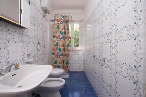 uma casa de banho com um lavatório, um WC e uma janela. em Trilocale vicino al mare a Numana - N129 em Marcelli