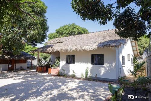 a small white house with a thatched roof at tsarajoro in Mahajanga