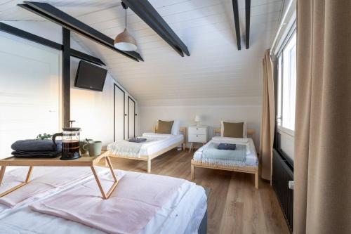 1 dormitorio con 2 camas y TV. en Rovaniemi, cozy villa for 10 with sauna, en Rovaniemi