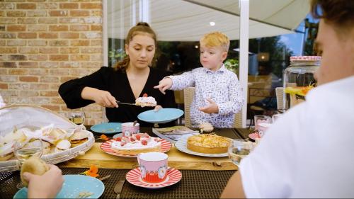 una donna e un bambino che mangiano una torta a un tavolo di De Pluktuin a Kortessem