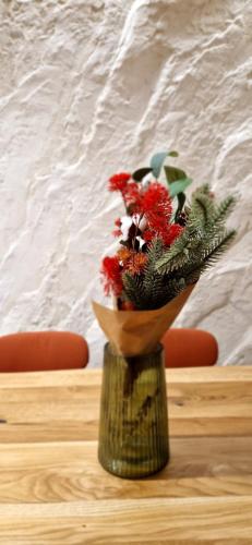 a vase with flowers in it on a table at Котедж Gudz in Yaremche