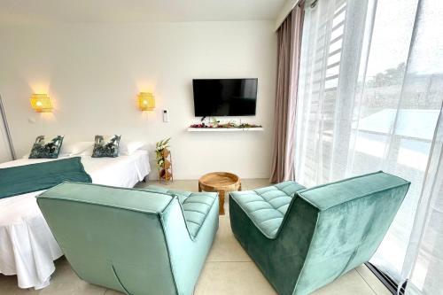 a hotel room with two beds and chairs and a tv at Studio Hanalei City brand new in the center of Papeete WiFi -Netflix -AC in Papeete