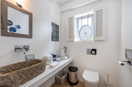 uma casa de banho com um lavatório, um WC e um espelho. em Quinta da Colina em Loulé