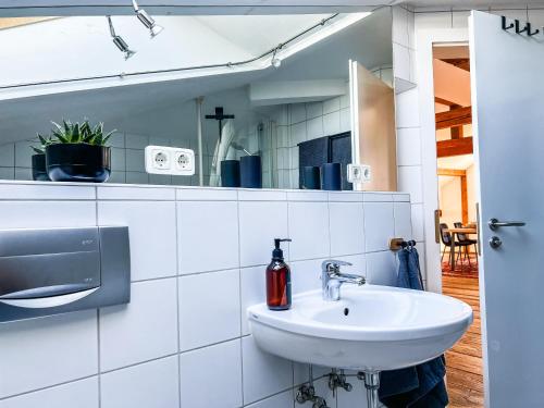 uma casa de banho branca com um lavatório e um espelho em Loft-Wohnung im Herzen von Prien - 100m2 - SmartTV em Prien am Chiemsee