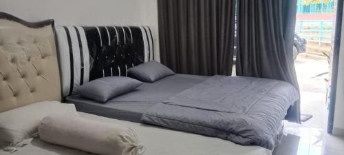 Sungaitutung的住宿－Natural hot spring homestay，一张带床头板和枕头的床