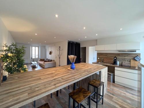 una cucina e un soggiorno con un grande tavolo in legno di Bel appartement ad Albertville