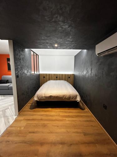 una camera con un letto e una parete nera di L'Orfèvrerie a Bourges