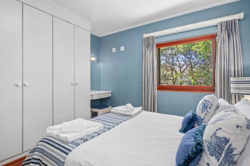 1 dormitorio con 1 cama grande y ventana en San Lameer Villa 12405 - 2 Bedroom Classic - 4 pax - San Lameer Rental Agency en Southbroom