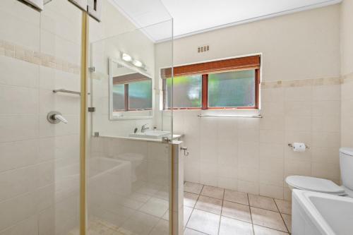 y baño con ducha, lavabo y aseo. en San Lameer Villa 12405 - 2 Bedroom Classic - 4 pax - San Lameer Rental Agency, en Southbroom