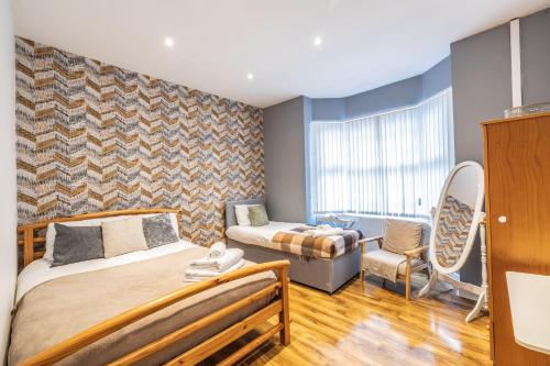 a bedroom with two beds and a chair at 4 bedroom Townhouse in West Bromwich