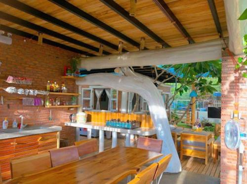 uma sala de jantar com uma mesa de madeira e uma tenda em Tropical Garden Oasis Villa em Phu Quoc
