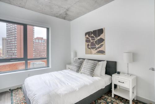 a white bedroom with a bed and two windows at Kendall Square 2br w gym near shops dining BOS-974 in Cambridge
